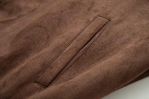 Detailed macro view of a welt pocket on brown faux suede bomber jacket with soft texture