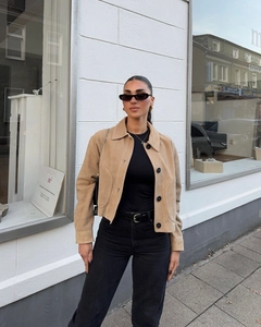 Detail of camel suede jacket with large pockets and front buttons in street style