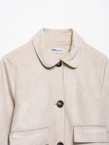 Detail der cremeweißen Wildlederimitatjacke mit Reverskragen und großen Pattentaschen