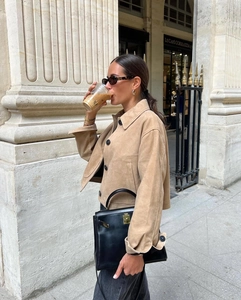 Close-up of khaki suede jacket featuring large black buttons and a classic lapel collar