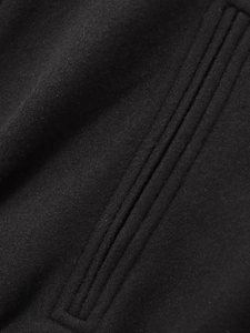 Detailaufnahme der schwarzen Wolltextur mit Parallelnähten und Taschennaht-Struktur
