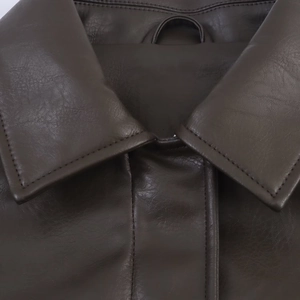 Close-up of dark brown leather jacket collar showing fine texture and tonal stitching