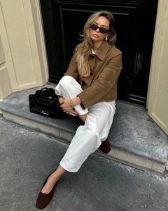 Style de rue avec une veste en daim marron, pantalon blanc et sac fourre-tout tissé