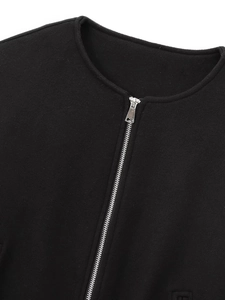 Detailansicht von Rundhalsausschnitt und Silberreißverschluss der schwarzen Bomberjacke