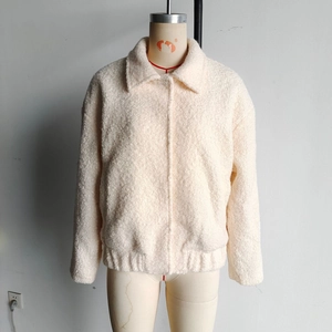 Detail view of women's off-white faux fur jacket with lapel collar and plush texture