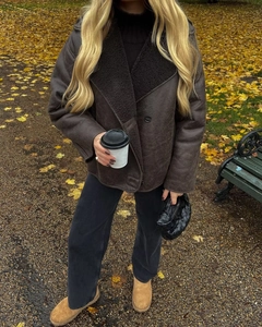 Detail of faux suede shearling jacket with black faux fur collar in autumn setting