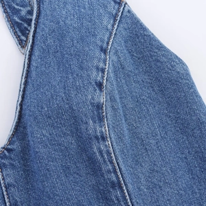 Detail of blue denim dress with contrast orange stitching and high-quality fabric texture