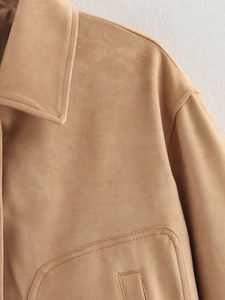 Close-up detail of camel suede jacket showing high-quality stitching and large pocket texture