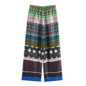 Detailed view of high-waisted satin wide-leg pants with vibrant geometric patterns
