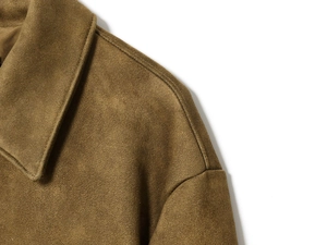Detailed macro view of the shoulder stitching on a brown suede texture cropped jacket