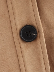 Macro shot of large black marble-textured button on khaki suede jacket fabric