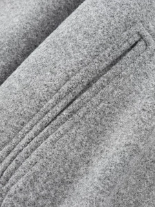 Detailaufnahme der grauen Wolljacke mit Fokus auf Seitentaschennähte und weiche Textur