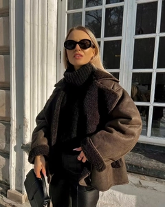 Detail of dark brown faux suede aviator jacket with thick black shearling collar and cuffs