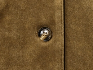 Detail of faux suede jacket featuring a marbled resin button and premium stitching