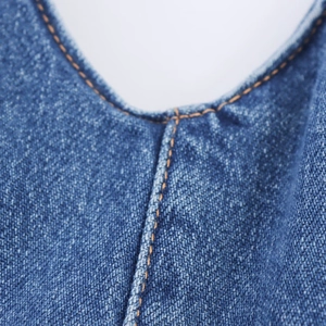 Close-up detail of halter neck backless denim dress showing stitching quality