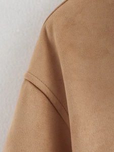 Close-up of shoulder seam on tan faux suede jacket featuring drop shoulder stitching details