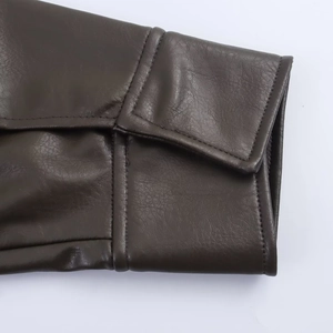 Detail of dark brown faux leather jacket cuff with fine texture and double stitching