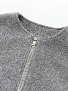 Detail der grauen Kurzjacke mit Wolltextur und silbernem Metallreißverschluss