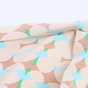 Detailed macro view of geometric print fabric showing pink circles and brown star patterns