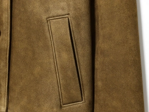 Close-up detail of dark brown suede jacket featuring a vertical welt pocket and neat stitching