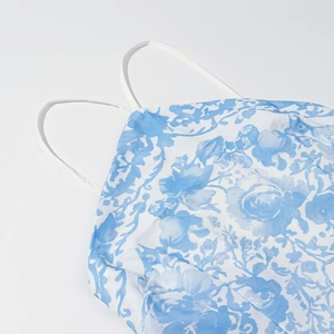 Détail de la robe licou à fleurs bleues et blanches avec fines bretelles et texture du tissu