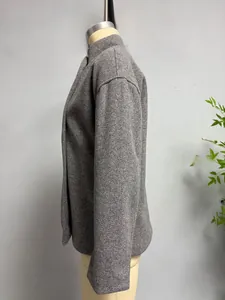 Detail of grey wool-blend textured jacket with high stand collar and structured sleeve profile