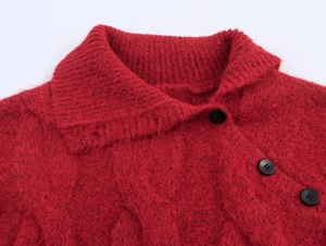 Detail of red cable knit cardigan with fuzzy texture and black vintage buttons