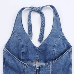 Detailed view of blue denim halter neck top with front zipper and orange stitching
