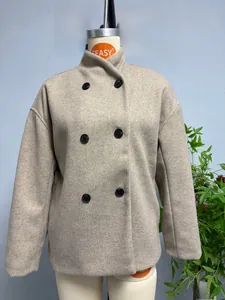 Close-up of beige double-breasted wool coat featuring six contrast black buttons and stand collar