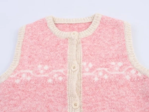 Close-up of pink jacquard knit vest with soft plush texture and white geometric pattern