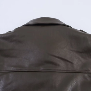 Detail of deep brown faux leather jacket collar showing fine texture and stitching