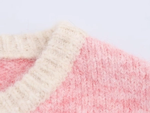 Close-up detail of soft pink and cream knit vest with fuzzy mohair texture and round neck