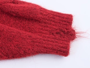 Detailed macro view of the fluffy red knit sweater cuff with ribbed texture and soft fur