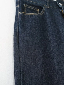 Detailansicht der dunkelblauen High-Waist-Jeans mit gelben Kontrastnähten und Seitentasche