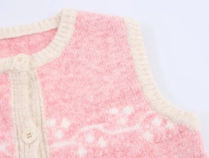 Detail of pink and white jacquard knit vest showing plush texture and front buttons