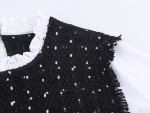 Detail der Tweed-Struktur mit weißem Rüschenkragen und Fransenbesatz am Kleid