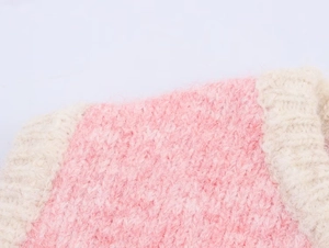 Macro detail of the plush pink and cream striped knit texture on this warm vest