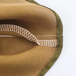Macro view of interior seams with olive edging and pink stitching on satin fabric