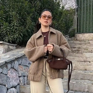 Women's autumn wool coat in brown oversized fit paired with trousers and a chic handbag
