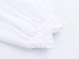 Detailansicht der elastischen gesmokten Bündchen mit Rüschen an einem weißen Kleid