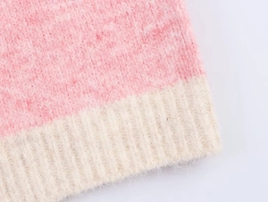 Close-up of pink and cream knit vest showing fluffy texture and ribbed hem detail