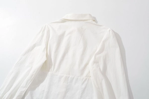 Vue détaillée d'une chemise blanche à manches longues avec broderie florale et coton