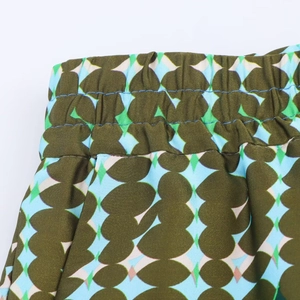 Macro detail of the elastic waistband with precise stitching on satin print trousers