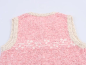 Detailed macro view of the fuzzy pink knit vest collar with intricate white floral jacquard