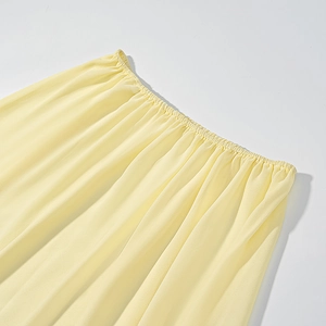 Détail de la taille élastique jaune clair avec texture plissée sur une robe trois pièces