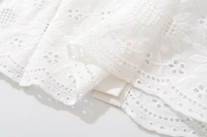Gros plan sur le tissu en coton blanc avec broderie anglaise et motifs floraux