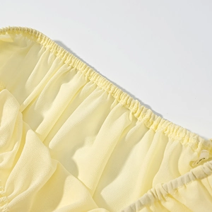Détail de la robe en mousseline jaune clair avec taille élastique froncée et coutures