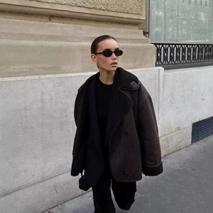 Brown faux shearling jacket featuring wide lapels and double-breasted buttons in street style