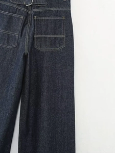 Detail der dunkelblauen Jeans mit Kontrastnähten und verstellbarer Schnalle am Bund