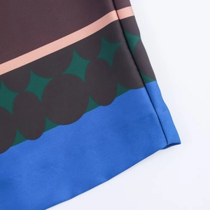 Detailed close-up of geometric pattern on silky satin shirt and high waist pants set